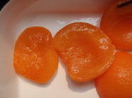 Köstliche eingemachte Aprikosen-Hälften im hellen keinem Sirup addieren alle künstlichen Farben